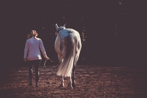 Jeune fille et son cheval de dos